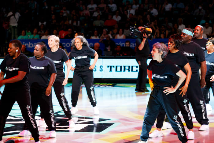 Members of the Timeless Torches perform on the court during a New York Liberty game.